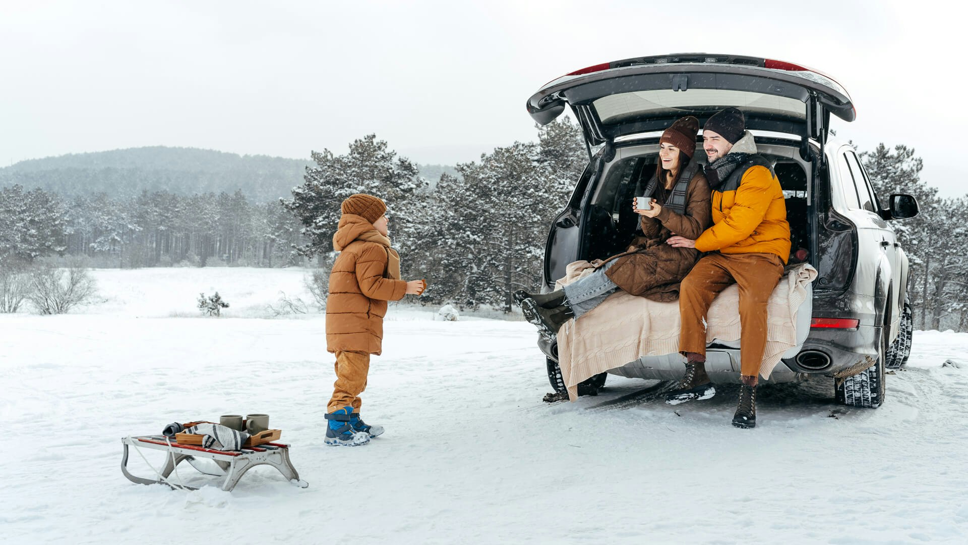 Eine Familie mit einem Schlitten und einem Auto im Schnee