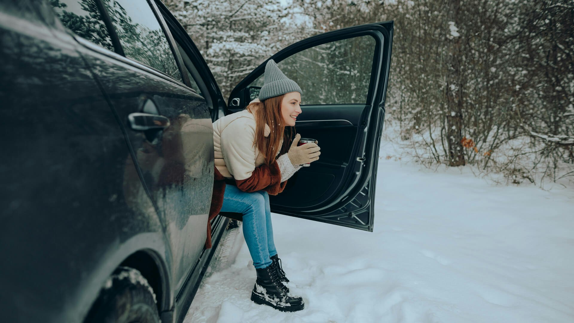 Eine Frau sitzt im Auto mit Schnee