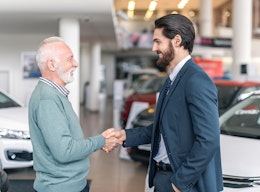Automobilverkäufer schüttelt die Hand eines Kundens