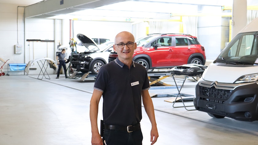 Vito Sammali mit einer ausgebauten Kofferraumabdeckung in der Werkstatt