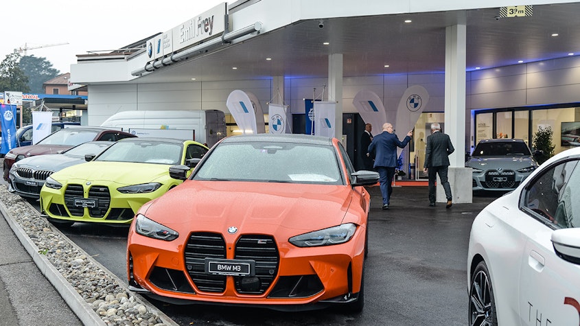 BMW M3 arancione davanti allo showroom