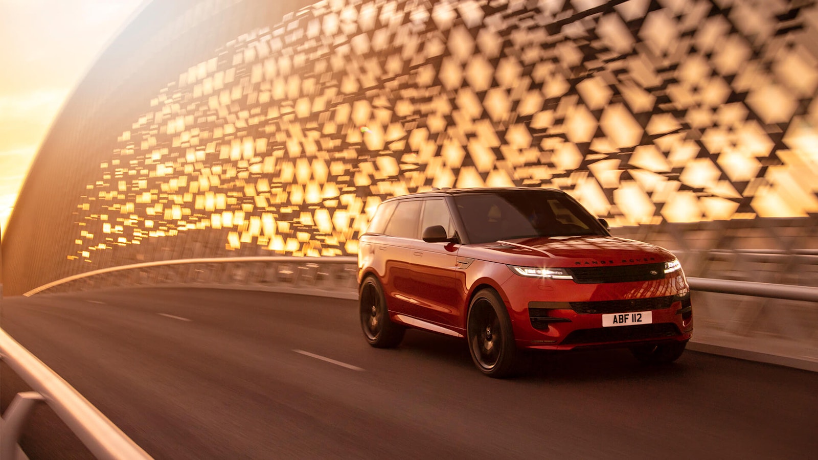 null Une Range Rover rouge passe sur un pont